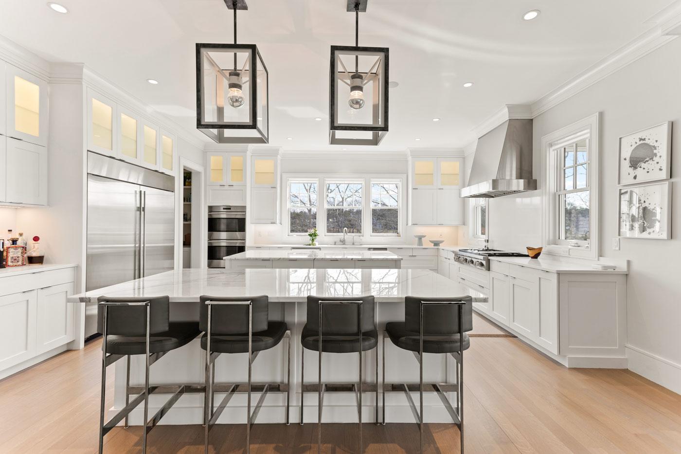modern white kitchen with 2 big stone islands in the center